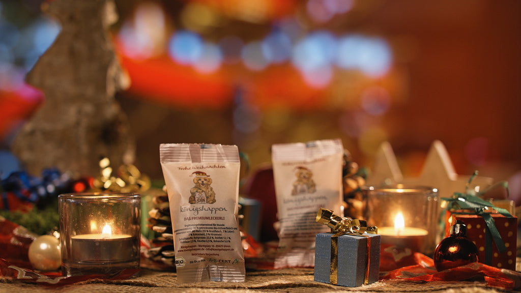 Königshappen Weihnachtsedition – zwei Päckchen in weihnachtlicher Dekoration mit Teelichtern